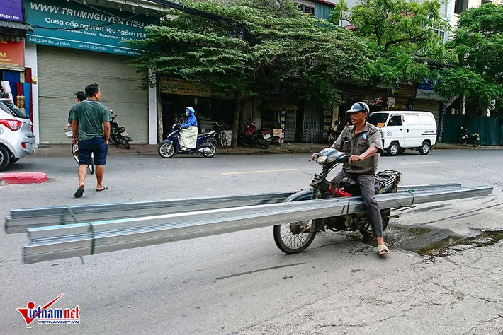 Những chiếc xe máy trơ khung, cũ nát được tận dụng để chở hàng từ những thanh sắt đến những tấm tôn vẫn tồn tại trên phố Hà Nội, uy hiếp người đi đường.