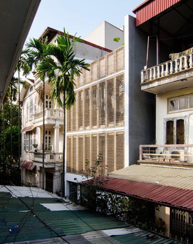 Trước cửa nhà được trồng một hàng cau xanh mướt kết hợp hoàn hảo với hệ thống cửa lam tre, tạo nên nét đẹp truyền thống hiếm có giữa khu phố hiện đại.