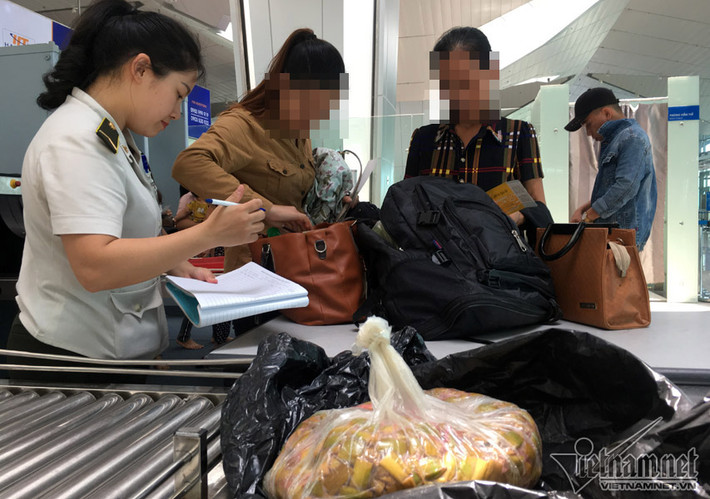 Dưa mùng muối bọc kít trong túi ni-lông đen của hành khách bị giữ lại cửa an ninh.