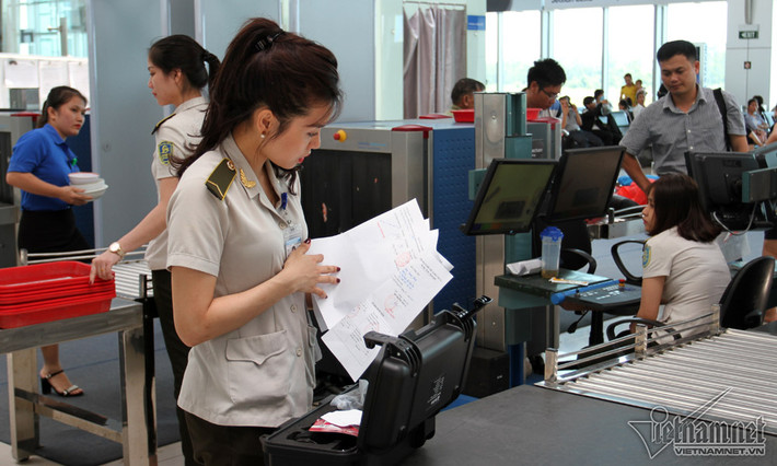 Nhân viên an ninh Nguyễn Thị Bích Ngọc kiểm tra giấy tờ liên quan đến một chiếc máy lạ mắt.
