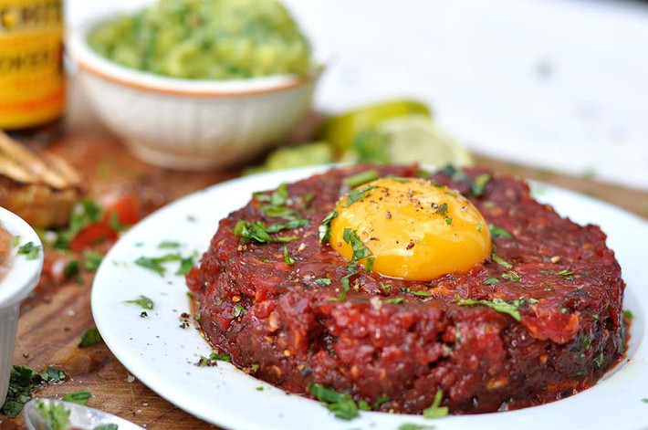 Steak Tartare (Pháp): Món ăn này gồm thịt bò hoặc thịt ngựa sống băm nhỏ, ăn kèm hành, bạch hoa và gia vị, đôi khi có thêm một quả trứng sống. Ảnh: Gran Luchito.