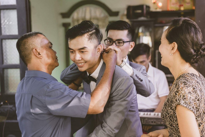 Ba mẹ Tuấn Điền trao quà cho hai con.