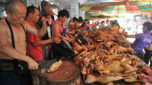 Những người bán thịt chó luôn tay chặt thịt cho khách mua.