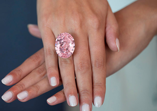 The Graff Pink Chiếc nhẫn tuyệt vời này có mặt là viên kim cương hồng hình chữ nhật bo tròn góc, hai bên là hai viên kim cương nhỏ màu trắng hình khiên. Năm 2010, chiếc nhẫn được bán tại Sotheby’s Geneva với giá 46,2 triệu USD (khoảng 1000 tỷ đồng).