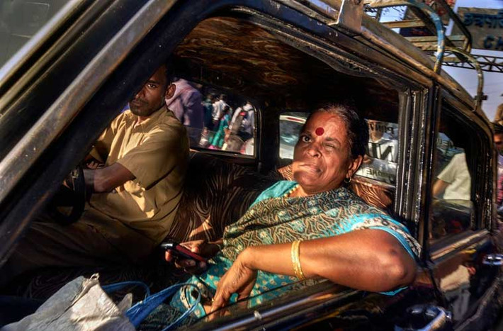Xe taxi Premier Padmini không có cửa kính bon bon trên một con phố Mumbai.