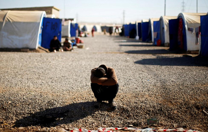 Một người đàn ông Iraq vừa chạy khỏi Mosul ngồi gục ở giữa con đường chính ở trại tị nạn Khazer. Trại này được lập nên chủ yếu để những người dân chạy trốn khỏi các vùng phiến quân IS chiếm đóng về đây tá túc. Ảnh Reuters