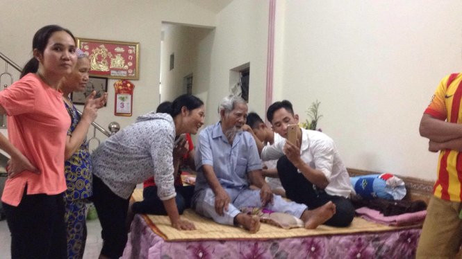 Cụ Lê Đình Kình về nhà, con cháu quây quần bên giường cụ. Chị Lê Thùy Dung (con gái út cụ Lê Đình Kình) chia sẻ: “Cụ về là rất mừng rồi. Cả nhà em vui lắm!”. Chia sẻ với Tuổi Trẻ về tình hình sức khỏe, cụ Lê Đình Kình nói: “Ông về rồi, ông chỉ thấy đang mệt”. (Ảnh: Nguyễn Khánh)