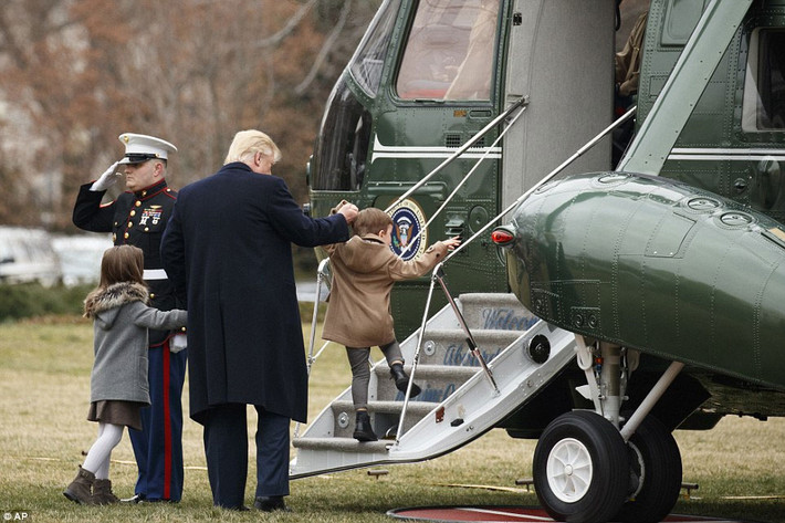 Tổng thống Trump cẩn thận dắt tay cháu lên bậc thang trực thăng. Ảnh Daily Mail