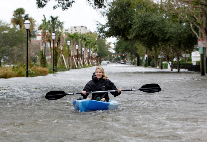 Một nữ công dân chèo thuyền kayak giữa Đại lộ Rutledge ngập nước ở thành phố Charleston.