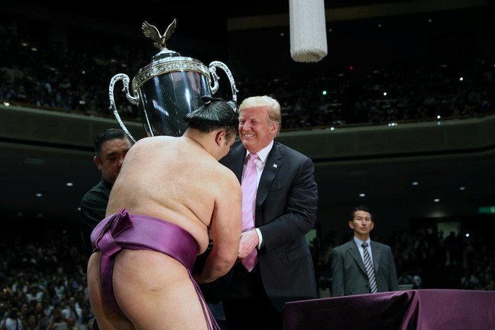 Do chiếc cúp khá nặng, ông Trump được một nhân viên giúp đỡ để trao nó cho võ sĩ Asanoyama. Ảnh: AP. *) Title do Kiến Thức biên tập lại