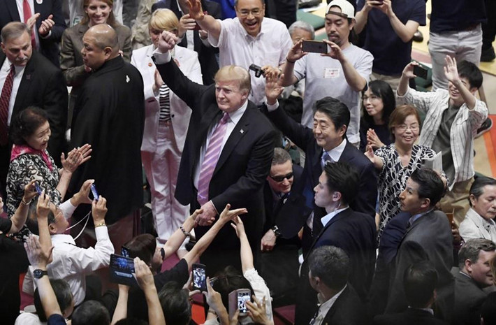 Việc xem sumo là một phần trong "kế hoạch thu hút" của Thủ tướng Nhật Shinzo Abe với người đứng đầu Nhà Trắng, bên cạnh việc mời ông Trump chơi golf và ăn món bánh kẹp double cheeseburger vào bữa trưa. Nỗ lực này diễn ra trong bối cảnh ông Trump đang tỏ ý không hài lòng về thâm hụt thương mại giữa hai nước. Ảnh: Kyodo.