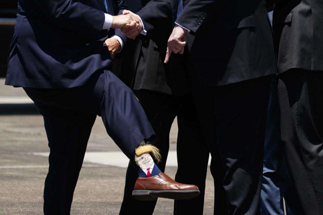Tổng thống Trump chú ý đến chiếc tất in hình ông của Phó thống đốc bang Louisiana Billy Nungesser sau khi đến Sân bay Quốc tế Chennault. Ảnh: AP.