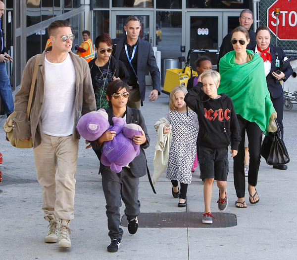 Angelina Jolie cùng chồng và các con trở về sau chuyến du lịch Úc vào năm 2014. Đi đầu ôm con gấu bông màu tím là Pax Thien Jolie-Pitt, cậu bé được Jolie nhận nuôi từ một trại trẻ mồ côi ở TP HCM, Việt Nam.