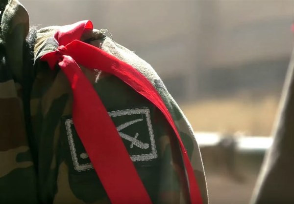 Một binh sỹ Syria đeo băng ruy băng đỏ ra chiến tuyến.