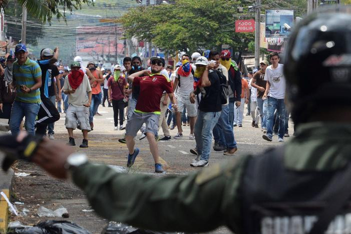 Người biểu tình quá khích ném chai lọ về phía lực lượng Vệ binh Quốc gia Venezuela.