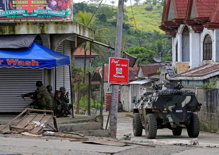 Xe bọc thép của quân đội chính phủ di chuyển trên con đường ở Marawi.