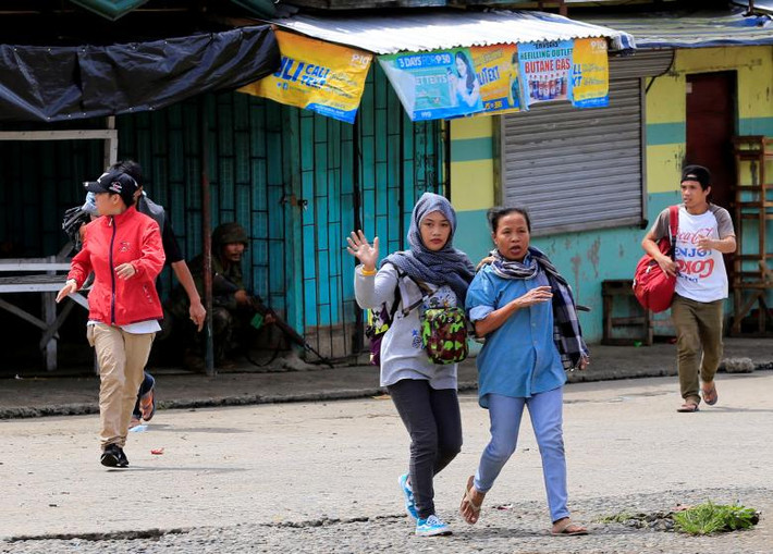 Những người dân chạy sơ tán trong lúc các binh sỹ chính phủ tấn công vào nhóm khủng bố nam Philippines là Maute sau khi chúng chiếm giữ thành phố Marawi trên đảo Mindanao.