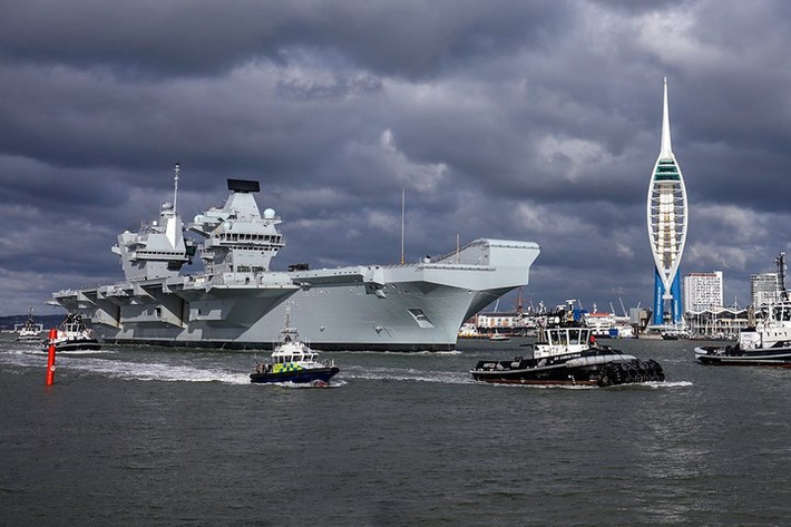 Tàu chiến HMS Queen Elizabeth đi qua tháp Spinnaker, với sự hộ tống của cảnh sát, vào tháng 2/2018.