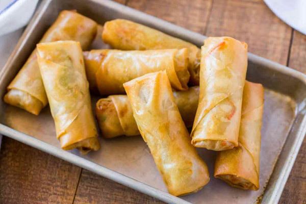 Chả giò: món ăn gồm các cuộn hình trụ có nhân rau hoặc thịt. Nhân được gói trong giấy gói bột mỏng. Chả giò khi chiên có màu vàng ươm, trông giống như miếng vàng mang ý nghĩa một năm “tiền vào đầy túi”. Ảnh minh họa