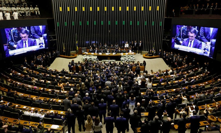Ông Jair Bolsonaro tuyên thệ nhậm chức tổng thống trước Quốc hội Brazil. Trong bài phát biểu ngắn trước các đại biểu, Bolsonaro cảm ơn Chúa vì để ông sống sót sau vụ tấn công bằng dao chí tử trong chiến dịch bầu cử và kêu gọi các nghị sĩ chung tay giúp Brazil thoát khỏi "tham nhũng, tội phạm và sự vô trách nhiệm trong kinh tế và sự phục tùng ý thức hệ". Ảnh: Reuters.