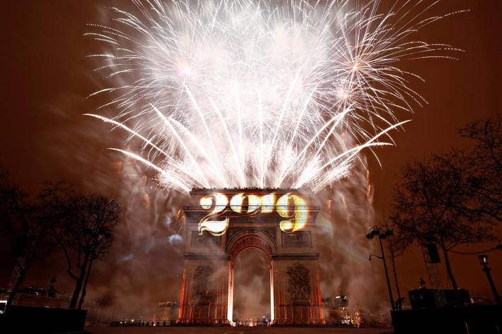 Khách du lịch và nhiều người dân thủ đô Paris, Pháp, đón chào Năm mới 2019 bằng màn trình diễn ánh sáng và pháo hoa với chủ đề "tình anh em" tại Khải Hoàn Môn ở đại lộ Champs-Elysees, trong bối cảnh an ninh được siết chặt nhằm ngăn chặn làn sóng biểu tình "Áo vàng". Nguồn ảnh: Reuters.