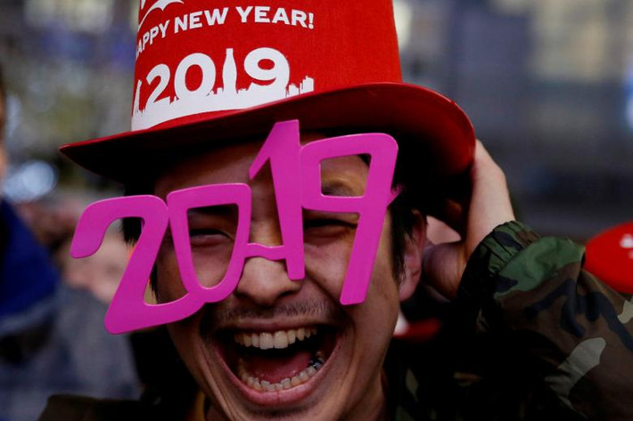 Một người đàn ông đeo kính có hình năm 2019 tại sự kiện đón chào năm mới tại ngã tư Shibuya ở Tokyo, Nhật Bản. Nguồn ảnh: Reuters.