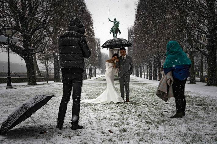 Một cặp vợ chồng tạo dáng chụp ảnh giữa trời tuyết ở Paris. Công viên phủ đầy tuyết gần sông Seine ở Paris mang đến bối cảnh ấn tượng và lãng mạn cho bộ ảnh của cặp đôi mới cưới này.