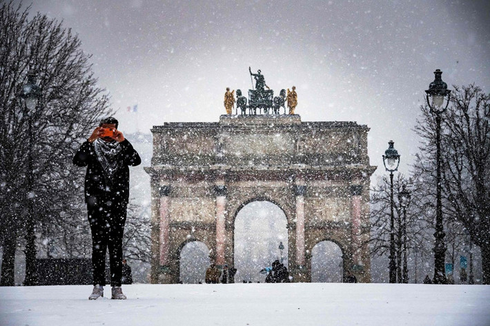 Một người đàn ông chụp ảnh trong khu vườn Tuileries khi tuyết rơi ở Paris. Các công trình nổi tiếng của Pháp đều bị bao phủ bởi tuyết trắng. Thời tiết ảm đạm với mây mù và gió lạnh cũng đang hoành hành ở một phần Tây Âu.