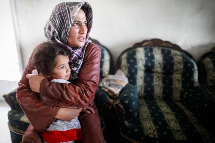 Hai mẹ con ôm nhau khi máy bay quân sự dội bom trên các con phố gần nhà họ ở Aleppo, Syria.