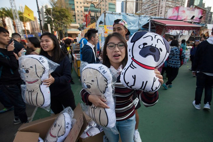 Sinh viên ở Hong Kong tranh thủ bán những chú chó nhồi bông kiếm thêm thu nhập trong dịp Tết. Ảnh: AAP.