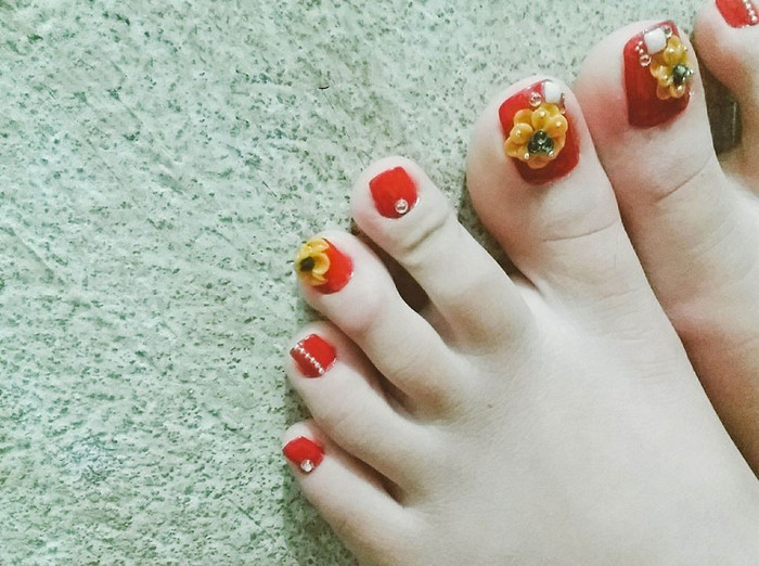 Bộ nail này ngoài nhược điểm trông "hơi quê" thì thực sự chỉ cần khoe chân thế này thôi đã thấy không khí Tết rồi.