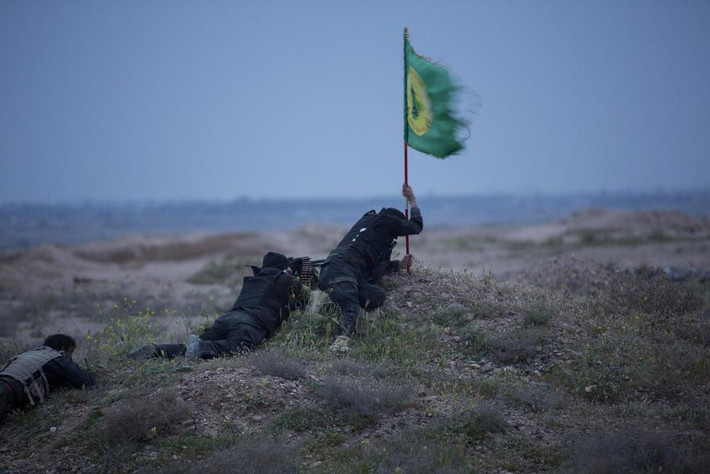 Anh chiến binh này đang cố gắng cắm cờ của người Shi'ite ở miền bắc Tikrit, Iraq.