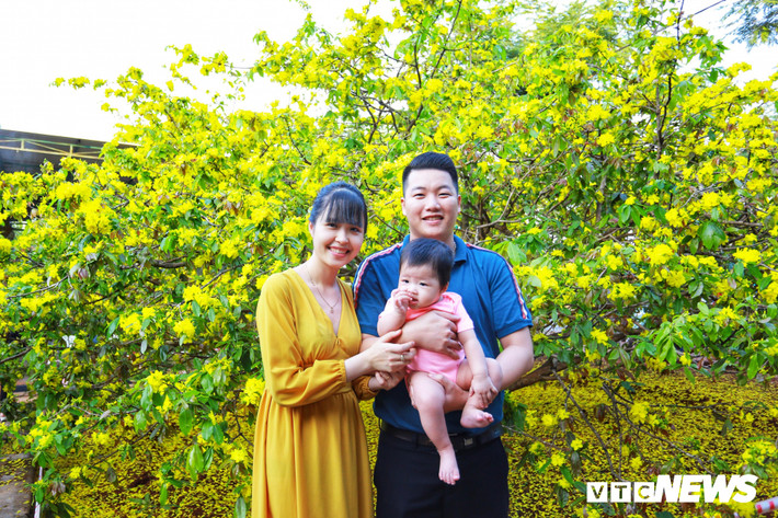 Một gia đình nhỏ chụp hình kỷ niêm bên cây mai.