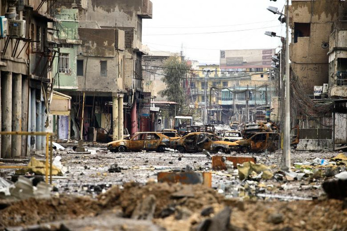 Hàng loạt xe ô tô bị cháy rụi trên một con đường ở Mosul. Ảnh Reuters