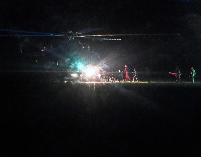 Binh sỹ cùng các nhân viên y tế hộ tống đưa nạn nhân lên máy bay. Ảnh: AFP/ Getty.