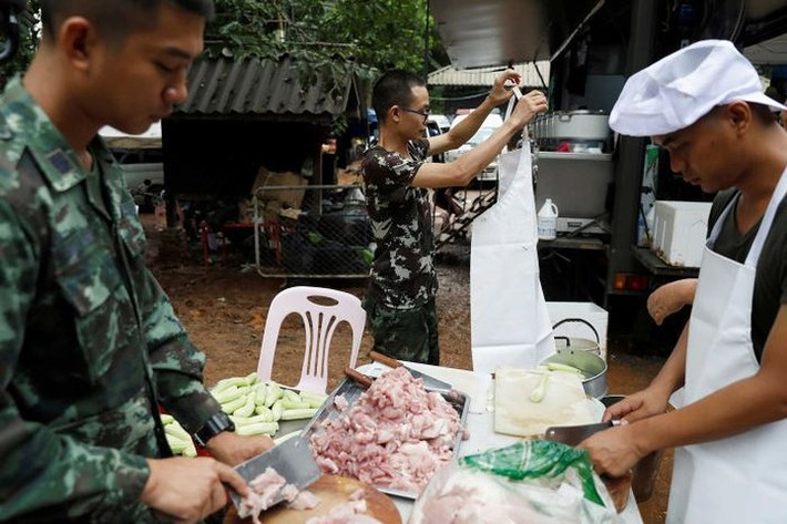 Các tình nguyện viên tham gia nấu nướng. Ảnh: Reuters.