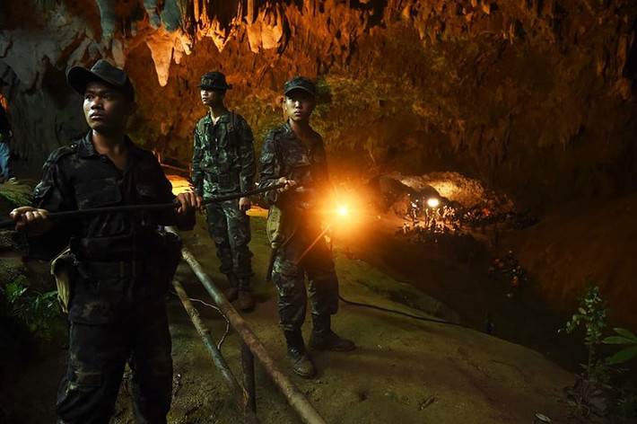Binh sĩ Thái Lan kéo cáp dẫn điện sâu vào bên trong hang. Ảnh: AFP