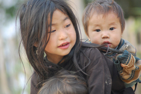 Hình ảnh một người chị cõng em trên lưng. Ảnh: Doanthanhnien.