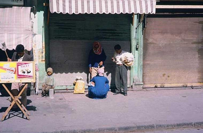 Những người dân Syria đi chợ đang đứng nghỉ bên một cửa hàng đóng cửa. Ảnh OLA