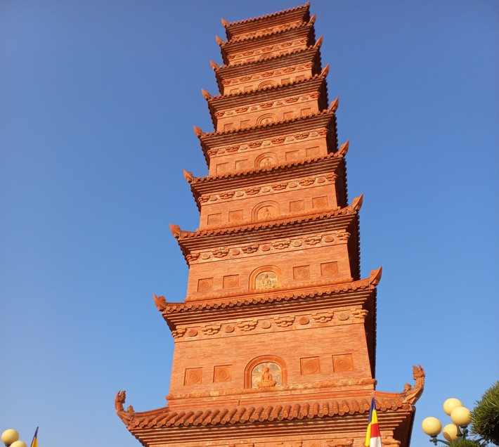 Từ xa, có thể nhìn thấy ngọn tháp bề thế. Bên ngoài tháp được lát bằng gạch và đá hoa cương mang sắc đỏ cổ kính. Phần mái tháp trang trí những hoa văn như đóa sen, đóa cúc được chạm khắc tỉ mỉ, tinh xảo.