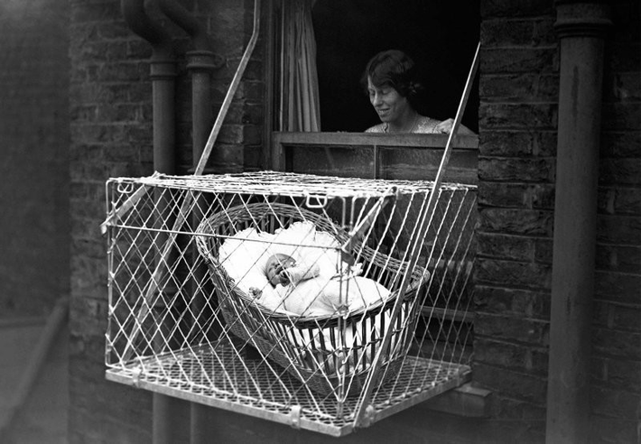 1. Cũi treo ngoài cửa sổ (1937): Một chiếc cũi bằng lồng kim loại được treo bên ngoài tòa nhà cao tầng ở London để trẻ em "hít khí trời" – phát minh táo bạo nhưng đầy rủi ro. (Ảnh: Fishki.net)