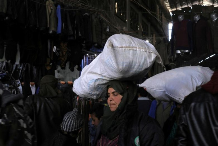 Manbij đã "đổi chủ" 3 lần kể từ khi cuộc xung đột ở Syria bùng phát năm 2011. Quân đội Syria Tự do đã chiếm thành phố này từ lực lương chính phủ, nhưng sau đó lại để mất vào tay IS. Ảnh: Một phụ nữ đang đội bao tải trên đầu ở một khu chợ của Manbij.