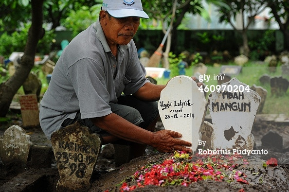 Ông Subekti,một người trông mộ đang chăm sóc mộ phần của nạn nhân Hayati Lutfiah Hamid.