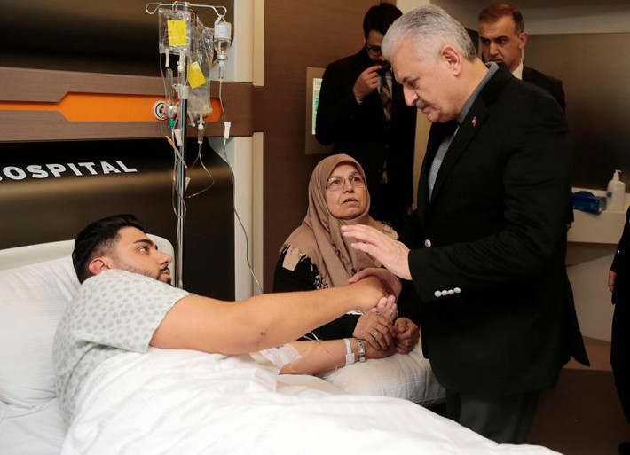 Thủ tướng Thổ Nhĩ Kỳ Binali Yildirim hỏi thăm sức khỏe một nạn nhân sống sót sau vụ xả súng kinh hoàng ở Thổ Nhĩ Kỳ. Ảnh The Sun