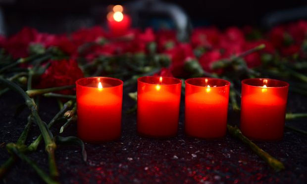 Mọi người đặt hoa và nến bên ngoài hộp đêm Reina để tưởng nhớ những người đã chết. Ảnh The Guardian