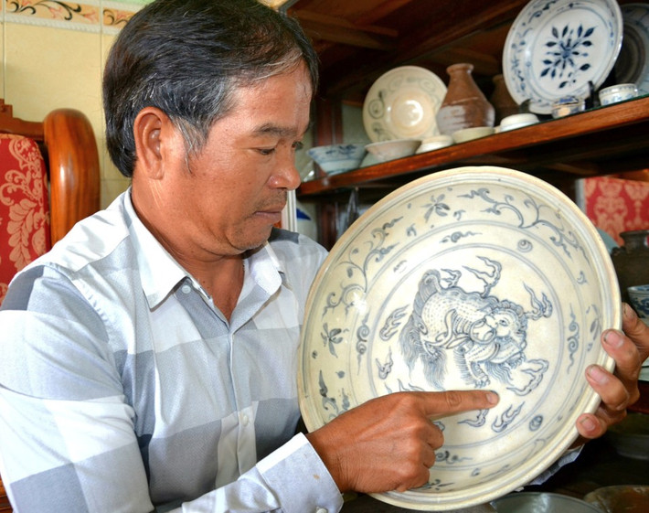 Một trong những "báu vật" của ông Vương là chiếc đĩa có đường kính 33cm, tráng men xanh, ẩn long, đồ gốm Chu Ðậu, khoảng thế kỷ 15 - 16.