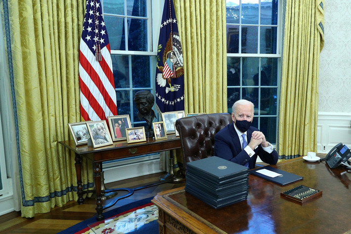Cờ biểu trưng cho các nhánh của quân đội Mỹ mà ông Trump trưng bày sau bàn làm việc được thay thế bằng một lá quốc kỳ và một lá cờ thể hiện con dấu tổng thống. Ảnh: Reuters.