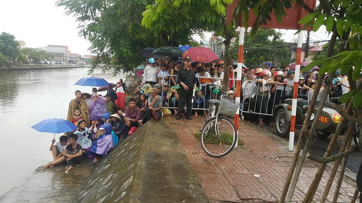 Mặc dù trời đang mưa nặng hạt nhưng với tình cảm dành cho Chủ tịch nước, người dân vẫn đứng đợi. Ảnh Hải Ninh