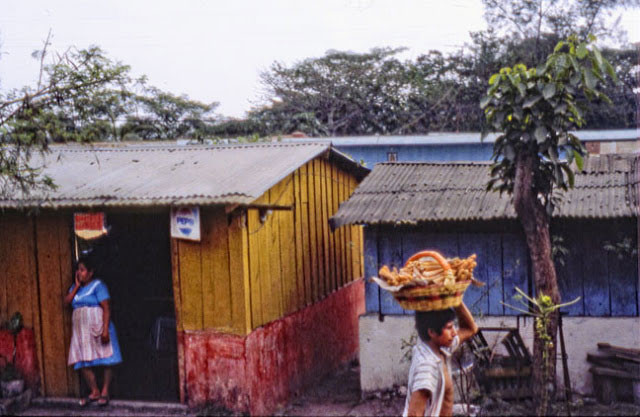 Người đàn ông đội rổ bánh đi bán ngoài đường. Ảnh VT