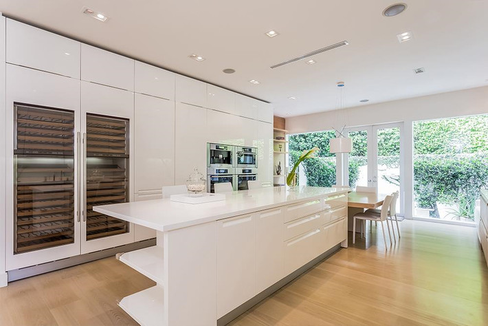 Nhà bếp mang vẻ đẹp tinh tế của sự tối giản với tông màu trắng chủ đạo và những trang thiết bị nấu nướng cao cấp được đặt gọn trong một chiếc tủ lớn.